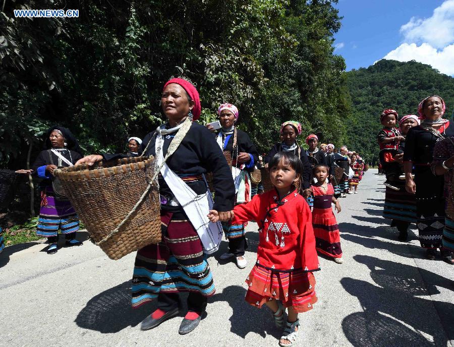 People attend a celebration activity of 'new rice' festival, a traditional event of the Wa ethnic group to pray for harvest, in Cangyuan County, southwest China's Yunnan Province, Oct. 3, 2015. Cangyuan is one of the major areas inhabited by people of the Wa ethnic group. [Xinhua]