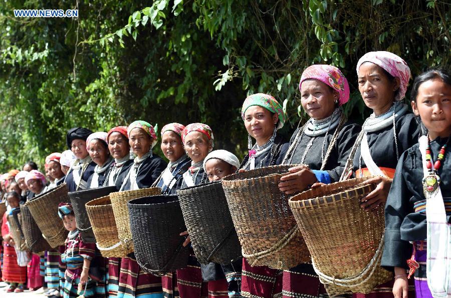 People carrying bamboo baskets attend a celebration activity of 'new rice' festival, a traditional event of the Wa ethnic group to pray for harvest, in Cangyuan County, southwest China's Yunnan Province, Oct. 3, 2015. Cangyuan is one of the major areas inhabited by people of the Wa ethnic group. [Xinhua]