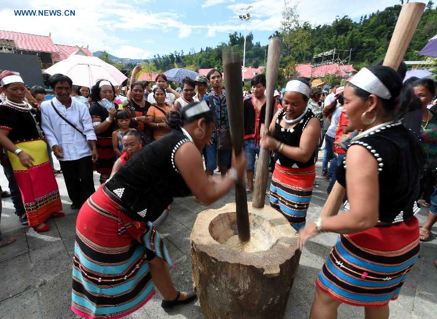 People attend a rice pestling contest during a celebration activity of 'new rice' festival, a traditional event of the Wa ethnic group to pray for harvest, in Cangyuan County, southwest China's Yunnan Province, Oct. 3, 2015. Cangyuan is one of the major areas inhabited by people of the Wa ethnic group. [Xinhua]