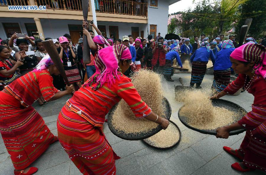 People attend a rice pestling contest during a celebration activity of 'new rice' festival, a traditional event of the Wa ethnic group to pray for harvest, in Cangyuan County, southwest China's Yunnan Province, Oct. 3, 2015. Cangyuan is one of the major areas inhabited by people of the Wa ethnic group. [Xinhua]