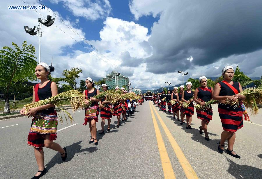 People attend a celebration activity of 'new rice' festival, a traditional event of the Wa ethnic group to pray for harvest, in Cangyuan County, southwest China's Yunnan Province, Oct. 3, 2015. Cangyuan is one of the major areas inhabited by people of the Wa ethnic group. [Xinhua]