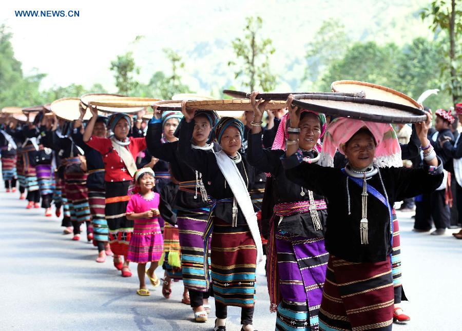 People attend a celebration activity of 'new rice' festival, a traditional event of the Wa ethnic group to pray for harvest, in Cangyuan County, southwest China's Yunnan Province, Oct. 3, 2015. Cangyuan is one of the major areas inhabited by people of the Wa ethnic group. [Xinhua]