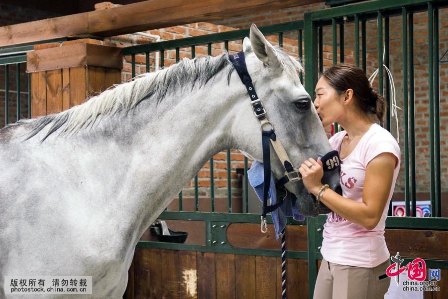 Tian Yu kisses the horse at the end of the competition. [Photo by Lan Yang/China.org.cn]