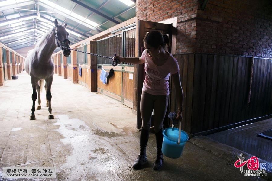 Tian Yu is ready to wash down her horse. [Photo by Lan Yang/China.org.cn]