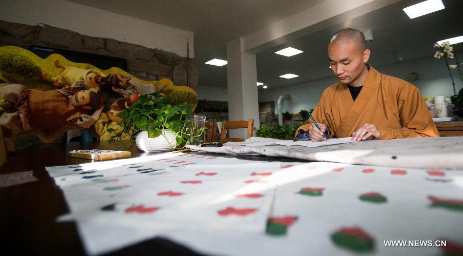 Master Xianfan draws cartoon image of Xian'er in Longquan Monastery in Beijing, capital of China, Sept. 27, 2015. [Xinhua]