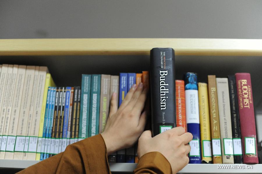 Curator of the Library, Master Xiancai, draws out a dictionary on Buddhism in Longquan Monastery in Beijing, capital of China, Sept. 21, 2015. [Xinhua]