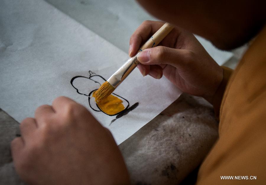 Master Xianfan draws cartoon image of Xian'er in Longquan Monastery in Beijing, capital of China, Sept. 27, 2015. [Xinhua]