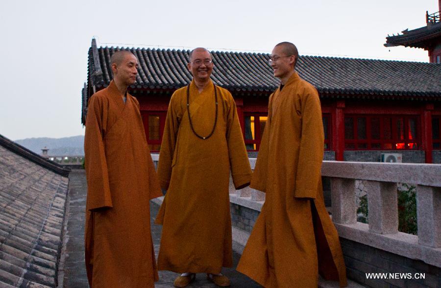 Master Xuecheng (R), President of the Buddhist Association of China and Abbot of Longquan Monastery, talks with two monks in Longquan Monastery in Beijing, capital of China, Oct. 1, 2015. [Xinhua]