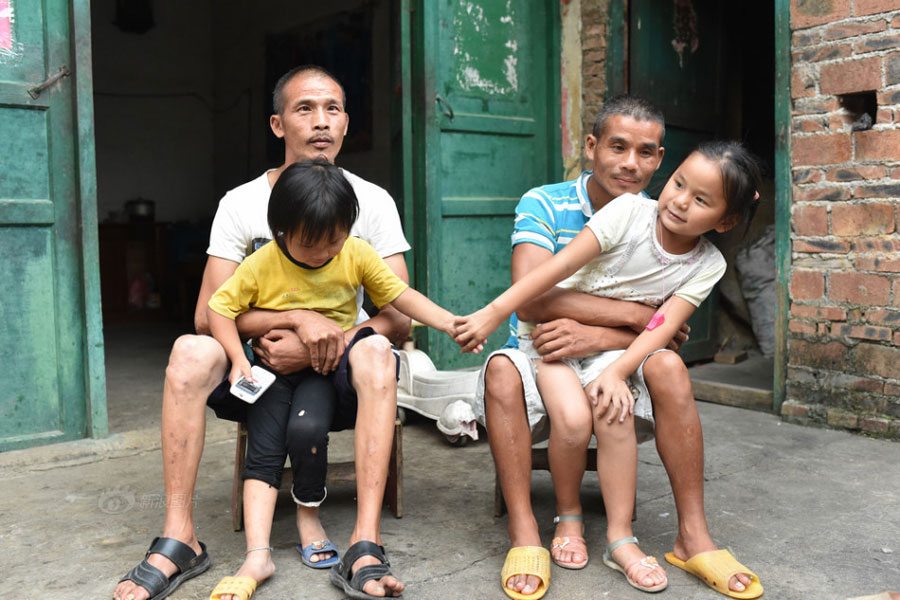 In the picture, Huang Huiying's two healthy granddaughters play with their two mentally-retarded uncles. [Photo/Sina]