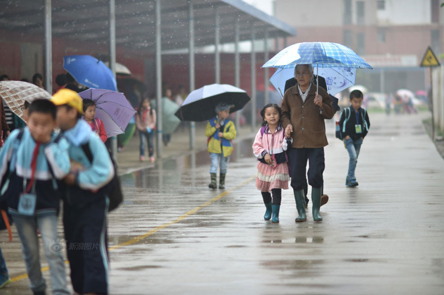 Huang Huiying sends her granddaughter to school, located three kilometers away from home, at six every morning after preparing meals for her three mentally-retarded children. [Photo/Sina]