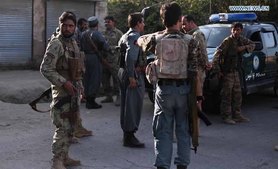 Policemen stand guard near a military vehicle in Kunduz city, Afghanistan, Oct. 9, 2015. Fierce clashes erupted between security forces and Taliban insurgents Friday night on the southern outskirts of Kunduz city, capital of Afghanistan's northern province of Kunduz. [Xinhua]