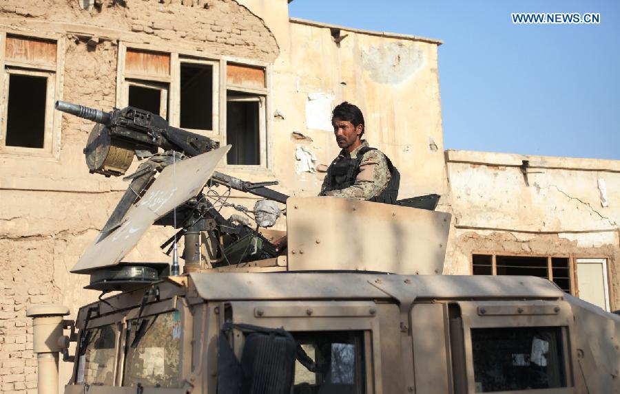 A policeman stands guard on a military vehicle in Kunduz city, Afghanistan, Oct. 9, 2015. Fierce clashes erupted between security forces and Taliban insurgents Friday night on the southern outskirts of Kunduz city, capital of Afghanistan's northern province of Kunduz. [Xinhua]