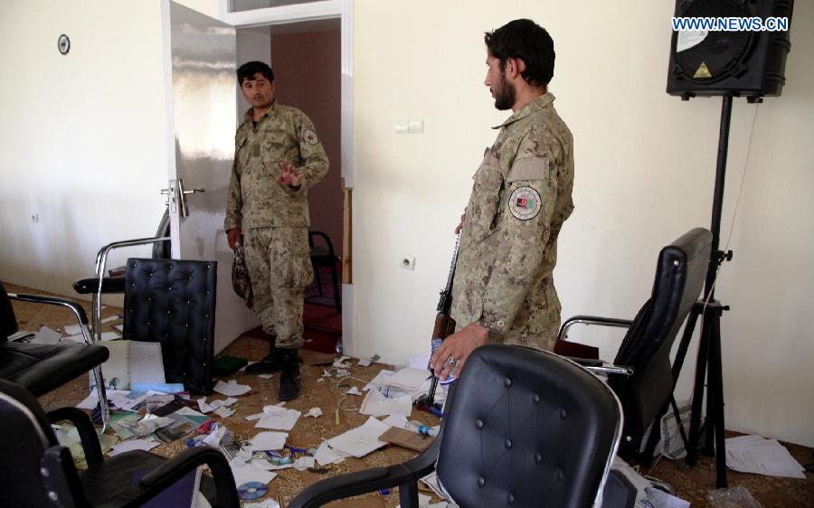 Policemen are seen at a destroyed room of a government building after Taliban militants burnt it down in Kunduz city, Afghanistan, Oct. 9, 2015. Fierce clashes erupted between the security forces and Taliban insurgents Friday night on the southern outskirts of Kunduz city, capital of Afghanistan's northern province of Kunduz. [Xinhua]