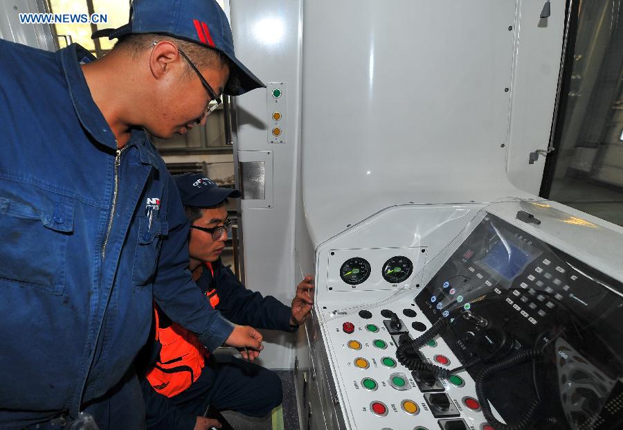 Workers tie up loose end of the autopilot subway train for the Yanfang Line of Beijing Subway at Changchun Railway Vehicles Co., Ltd in Changchun, capital of northeast China's Jilin Province, Oct. 15, 2015. The first autopilot subway train independently developed by China has come off the assembly line recently. It can automatically operate and recover during breakdowns. [Xinhua]