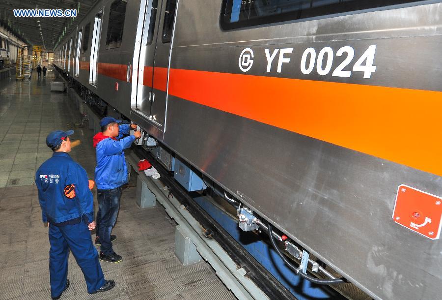 Workers tie up loose end of the autopilot subway train for the Yanfang Line of Beijing Subway at Changchun Railway Vehicles Co., Ltd in Changchun, capital of northeast China's Jilin Province, Oct. 15, 2015. The first autopilot subway train independently developed by China has come off the assembly line recently. It can automatically operate and recover during breakdowns. [Xinhua]