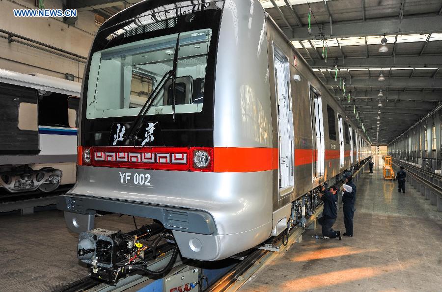 Workers tie up loose end of the autopilot subway train for the Yanfang Line of Beijing Subway at Changchun Railway Vehicles Co., Ltd in Changchun, capital of northeast China's Jilin Province, Oct. 15, 2015. The first autopilot subway train independently developed by China has come off the assembly line recently. It can automatically operate and recover during breakdowns. [Xinhua]