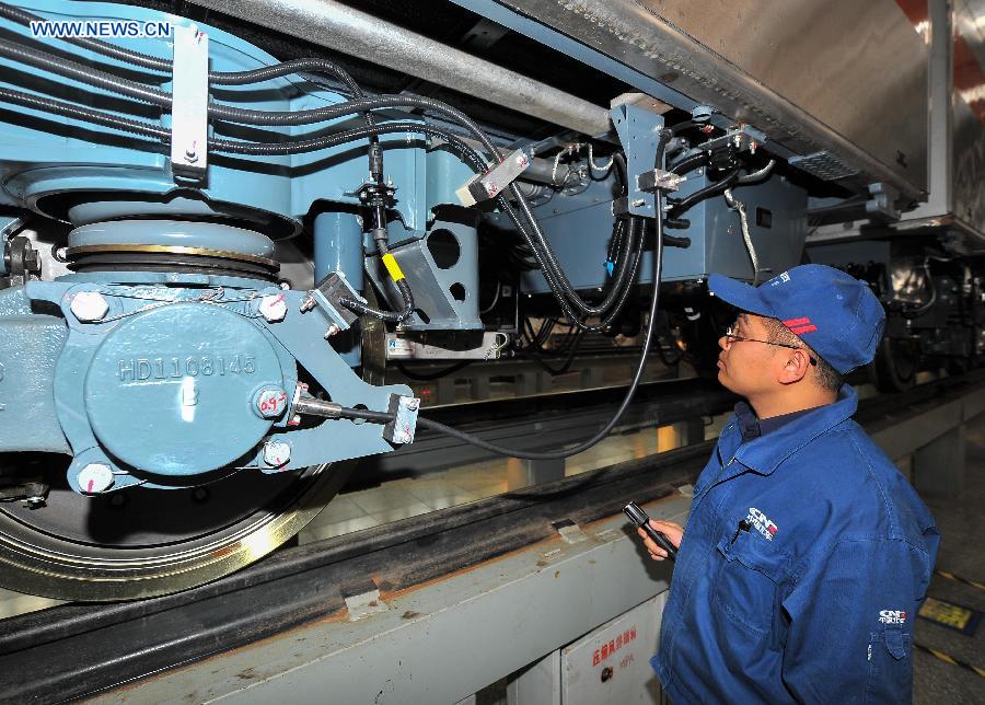 Workers tie up loose end of the autopilot subway train for the Yanfang Line of Beijing Subway at Changchun Railway Vehicles Co., Ltd in Changchun, capital of northeast China's Jilin Province, Oct. 15, 2015. The first autopilot subway train independently developed by China has come off the assembly line recently. It can automatically operate and recover during breakdowns. [Xinhua]