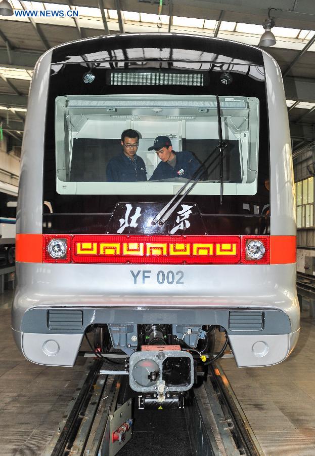 Workers debug the autopilot subway train for the Yanfang Line of Beijing Subway at Changchun Railway Vehicles Co., Ltd in Changchun, capital of northeast China's Jilin Province, Oct. 15, 2015. The first autopilot subway train independently developed by China has come off the assembly line recently. It can automatically operate and recover during breakdowns. [Xinhua]