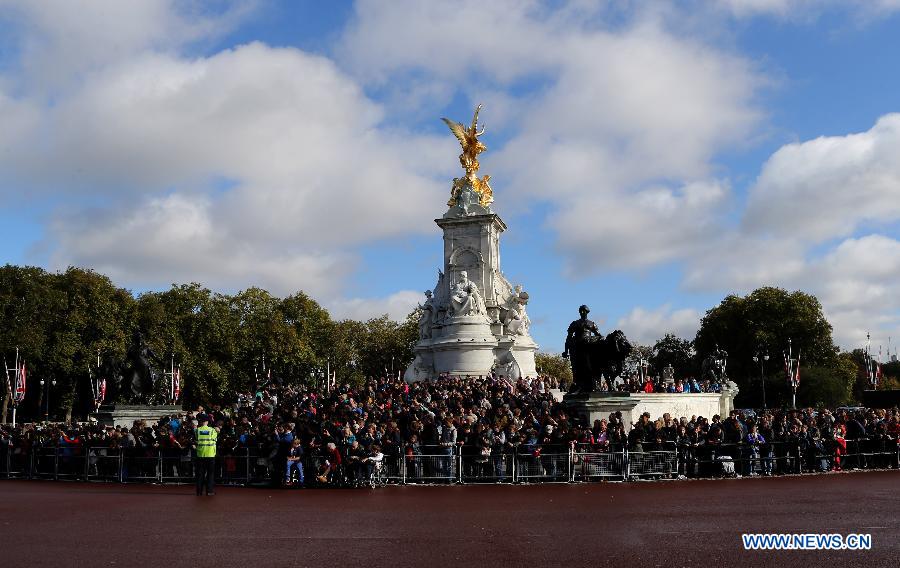 File photo shows people watching the changing ceremony of the British Royal Guards at the Buckingham Palace in London Oct. 16, 2014. The changing ceremony of the British Royal Guards is held at noon at the Buckingham Palace every day from May to July and evey other day in other months. [Xinhua]