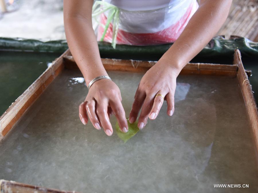 Ai Ying works at her family's paper-making workshop in Mangtuan Village of Gengma Dai and Wa Autonomous County, southwest China's Yunnan Province, Oct. 15, 2015. The time-honored Dai people's paper-making skill, with a history of several centuries, is mainly mastered by local women and was listed as a national intangible cultural heritage in 2006. Local villagers see it as a key money spinner. [Xinhua]