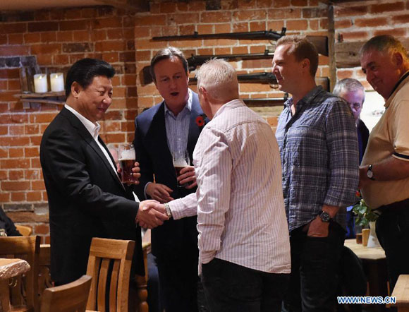 Chinese President Xi Jinping (1st L) and British Prime Minister David Cameron (2nd L) talk with local people at a pub after their meeting in Cameron's country retreat, Chequers, Britain, Oct. 22, 2015. [Photo/Xinhua]