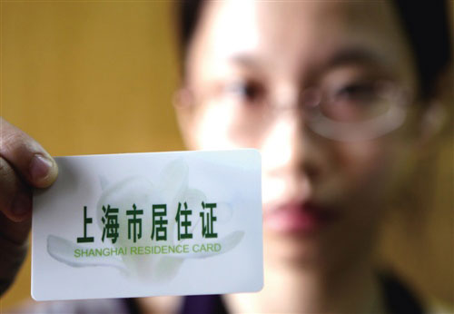 A person living in the city of Shanghai holds the new Shanghai Residence Card, a replacement of the long-existing temporary residence permit. [Photo: 21jingji.com] 