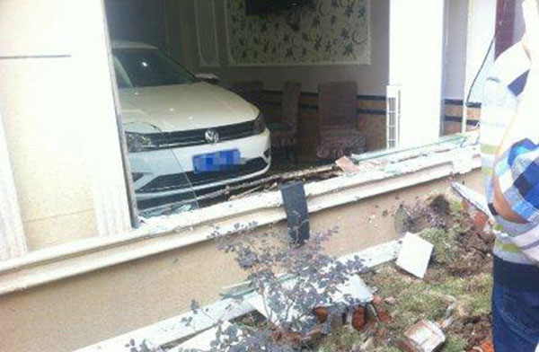 A sedan was driven into a hotel and crashed into a window and flower bed outside the building. [Photo from web] 