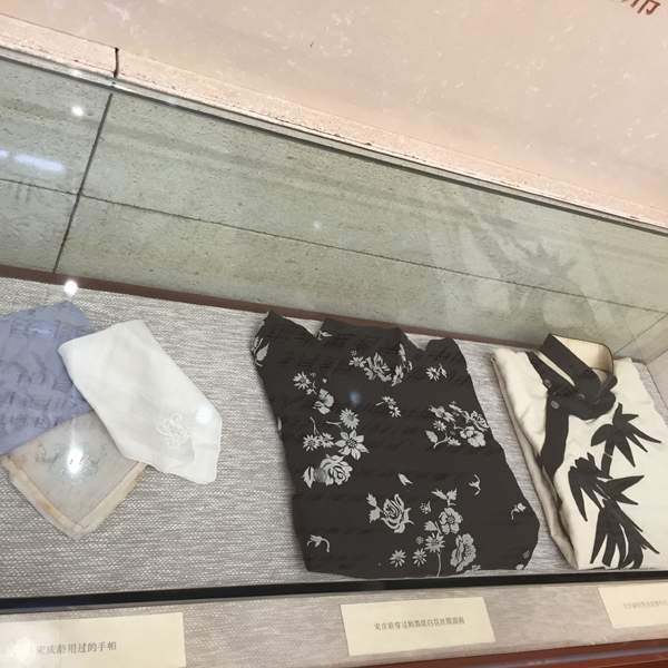 Several pieces of qipao, the body-hugging one-piece Chinese traditional dress, and handkerchiefs used by Madame Soong Ching Ling are on display at an exhibition marking the 100th anniversary of her marriage to Dr. Sun Yat-sen in Beijing on Oct. 25. [Photo by Guo Yiming/China.org.cn]