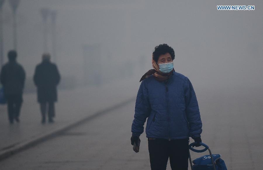 A woman wearing a mask walks on a smog-enveloped road in Changchun, capital of northeast China's Jilin Province, Oct. 25, 2015. (Photo: Xinhua/Lin Hong) 