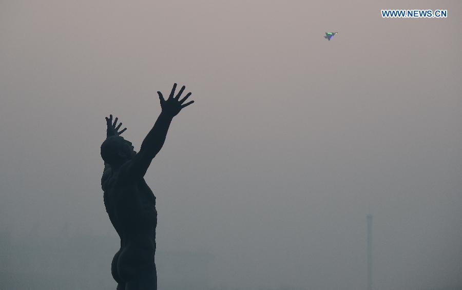 A remote control aircraft flies over a smog-enveloped square in Changchun, capital of northeast China's Jilin Province, Oct. 25, 2015. (photo: Xinhua/Lin Hong) 