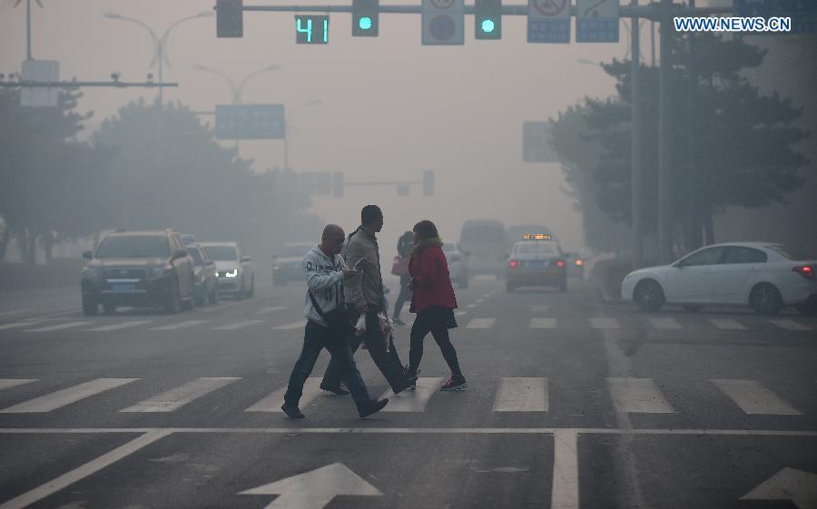 People walk on a smog-enveloped road in Changchun, capital of northeast China's Jilin Province, Oct. 25, 2015. (Photo: Xinhua/Lin Hong)