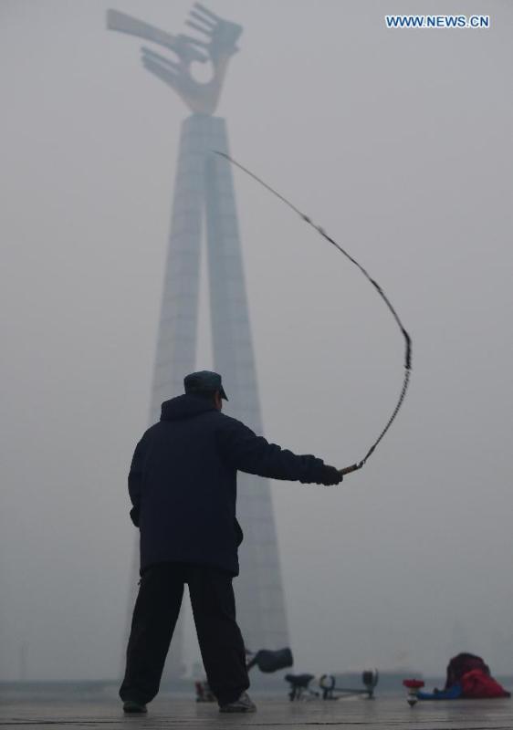 A man exercises on a smog-enveloped square in Changchun, capital of northeast China's Jilin Province, Oct. 25, 2015. (Photo: Xinhua/Lin Hong) 