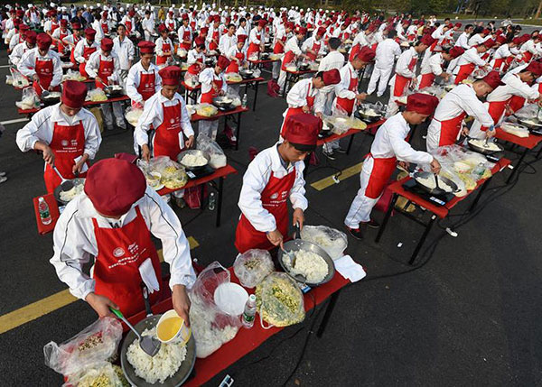 Four tons of fried rice is simultaneously cooking in Jiangsu province on Thursday. [Photo/Xinhua]