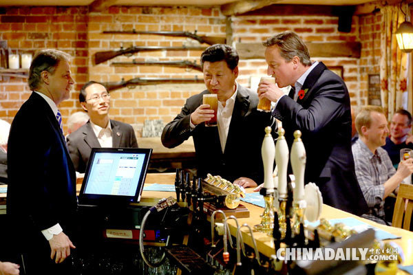 President Xi Jinping drinks a pint of beer with British Prime Minister David Cameron at The Plough at Cadsden pub in Princes Risborough, northwest of London, on Oct 22, 2015. The two leaders met for talks and dinner during a four-day state visit hailed as landmark by both China and Britain. [Photo/China Daily]