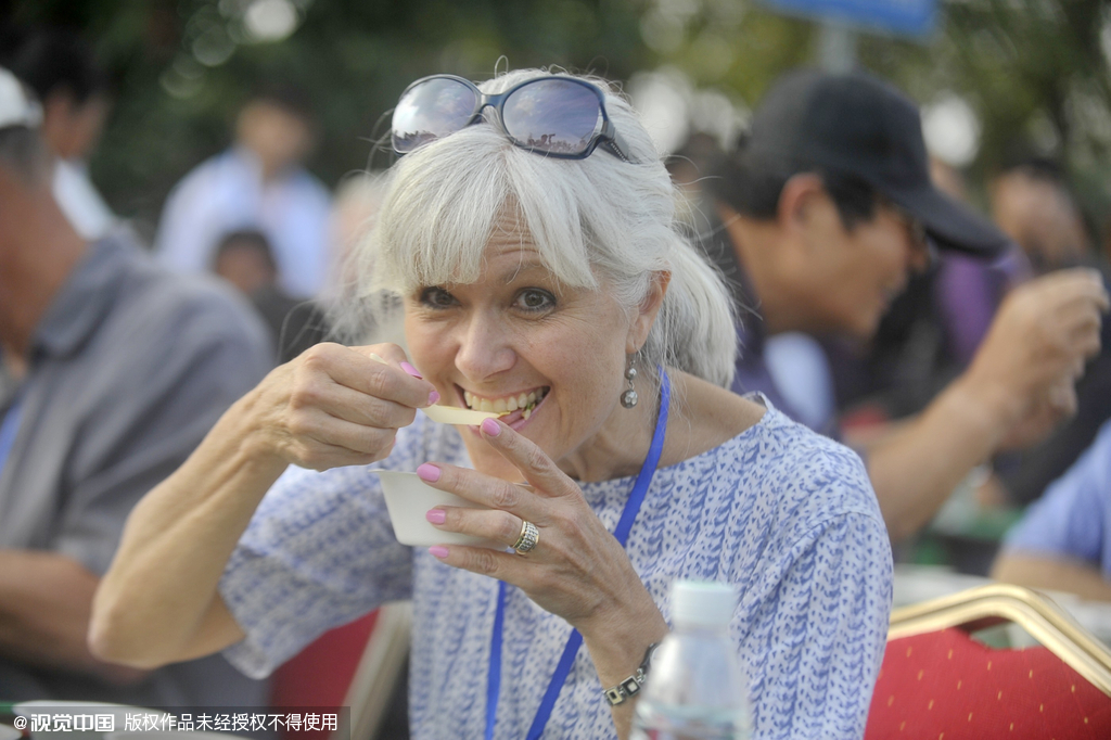 A foreign guest enjoys her fried rice in China’s eastern city of Yangzhou in Jiangsu Province on Oct 26, 2015.The biggest bowl of fried rice weighing 4,192 kilograms wowed the world but failed to be registered into the Guinness World Records due to food waste. [Photo/CFP] 