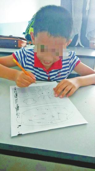 Undated photo shows 8-year-old Xiao Xuan (pseudonym) drawing a picture in central China's Henan province. [Photo: sina.com.cn]
