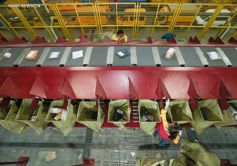 Workers sort out packages at a sorting center in Shanghai, east China, Nov. 11, 2015. The Singles' Day Shopping Spree, or Double-11 Shopping Spree, Chinese equivalent of Cyber Monday or Black Friday, is an annual online shopping spree falling on Nov. 11 for Chinese consumers since 2009. Each year the express delivery industry will face package peak after the shopping spree. [Xinhua]