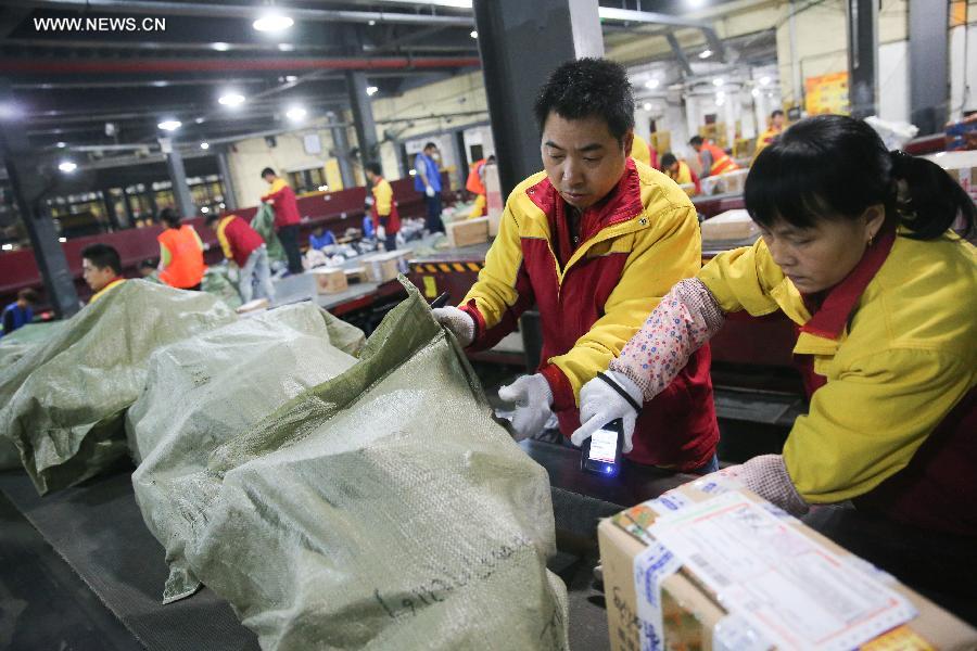 Workers sort out packages at a sorting center in Shanghai, east China, Nov. 11, 2015. The Singles' Day Shopping Spree, or Double-11 Shopping Spree, Chinese equivalent of Cyber Monday or Black Friday, is an annual online shopping spree falling on Nov. 11 for Chinese consumers since 2009. Each year the express delivery industry will face package peak after the shopping spree. [Xinhua]