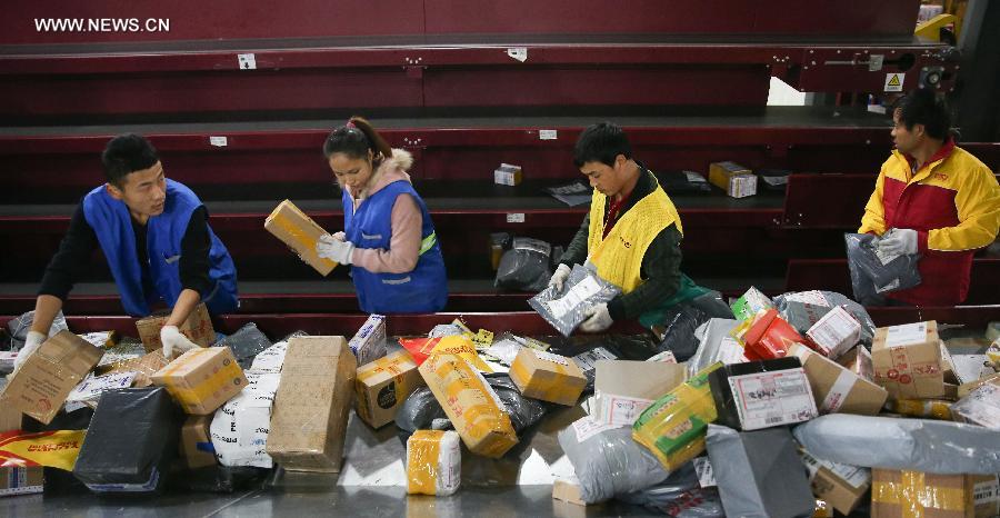 Workers sort out packages at a sorting center in Shanghai, east China, Nov. 11, 2015. The Singles' Day Shopping Spree, or Double-11 Shopping Spree, Chinese equivalent of Cyber Monday or Black Friday, is an annual online shopping spree falling on Nov. 11 for Chinese consumers since 2009. Each year the express delivery industry will face package peak after the shopping spree. [Xinhua]