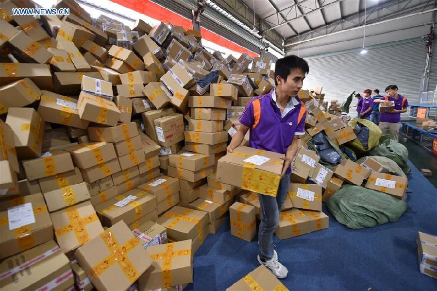 Workers sort out packages at a sorting center in Guangzhou, capital of south China's Guangdong Province, Nov. 11, 2015. The Singles' Day Shopping Spree, or Double-11 Shopping Spree, Chinese equivalent of Cyber Monday or Black Friday, is an annual online shopping spree falling on Nov. 11 for Chinese consumers since 2009. Each year the express delivery industry will face package peak after the shopping spree. [Xinhua]