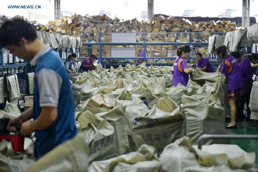 Workers sort out packages at a sorting center in Guangzhou, capital of south China's Guangdong Province, Nov. 11, 2015. The Singles' Day Shopping Spree, or Double-11 Shopping Spree, Chinese equivalent of Cyber Monday or Black Friday, is an annual online shopping spree falling on Nov. 11 for Chinese consumers since 2009. Each year the express delivery industry will face package peak after the shopping spree. [Xinhua]