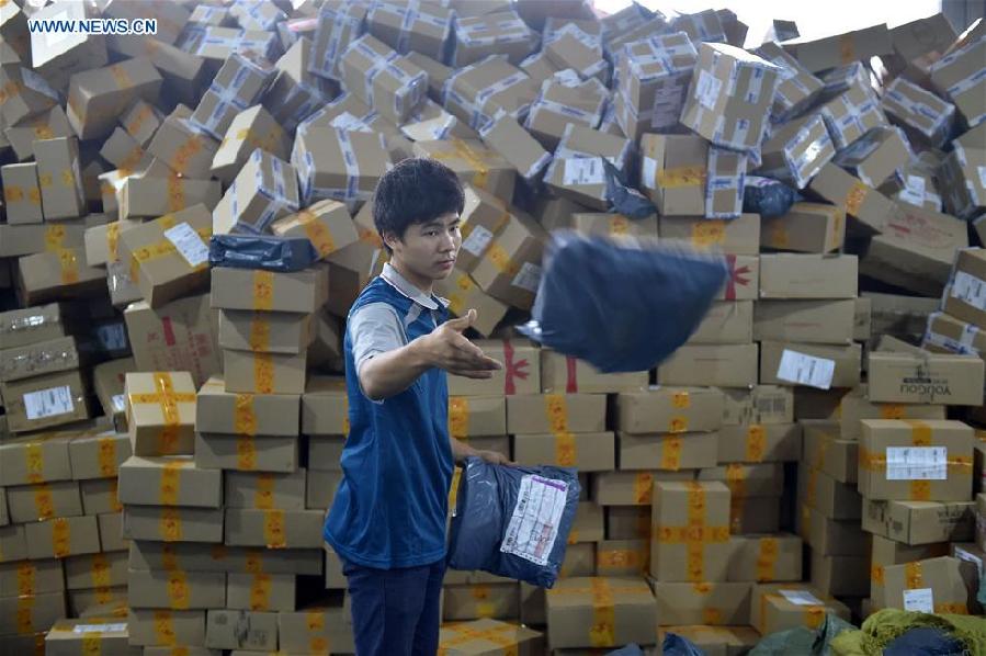 Workers sort out packages at a sorting center in Guangzhou, capital of south China's Guangdong Province, Nov. 11, 2015. The Singles' Day Shopping Spree, or Double-11 Shopping Spree, Chinese equivalent of Cyber Monday or Black Friday, is an annual online shopping spree falling on Nov. 11 for Chinese consumers since 2009. Each year the express delivery industry will face package peak after the shopping spree. [Xinhua]