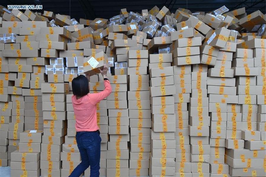 Workers sort out packages at a sorting center in Guangzhou, capital of south China's Guangdong Province, Nov. 11, 2015. The Singles' Day Shopping Spree, or Double-11 Shopping Spree, Chinese equivalent of Cyber Monday or Black Friday, is an annual online shopping spree falling on Nov. 11 for Chinese consumers since 2009. Each year the express delivery industry will face package peak after the shopping spree. [Xinhua]