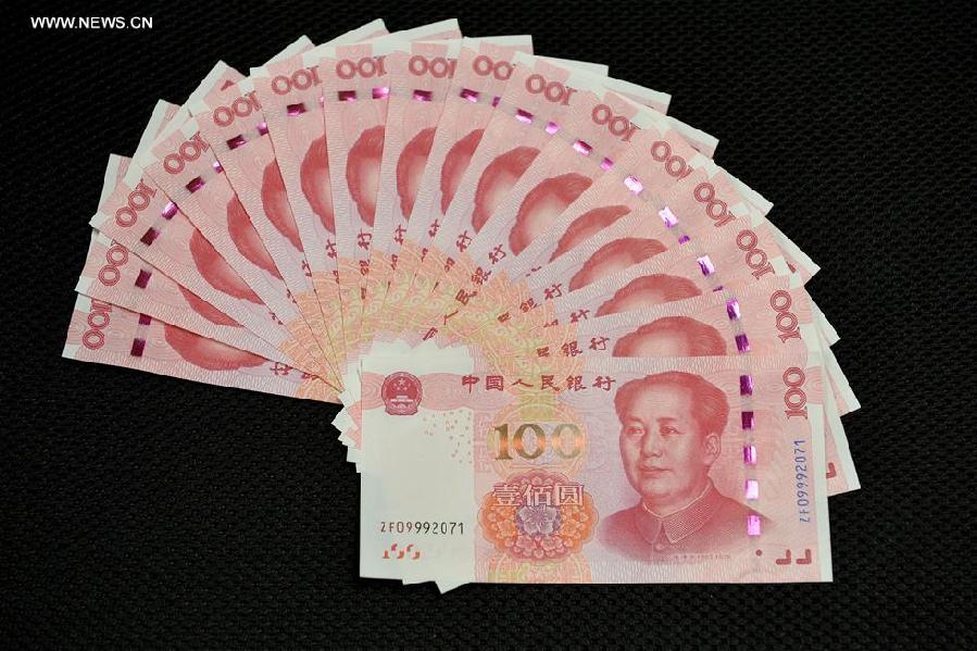 Photo taken on Nov. 12, 2015 shows newly-released 100-yuan banknotes in Beijing, capital of China. China's central bank released a new 100-yuan banknote on Thursday. The design stays largely the same as its former series, but the new banknotes are harder to conterfeit and easier for machines to read. The 100-yuan note is the largest denomination of the Chinese currency. [Xinhua]