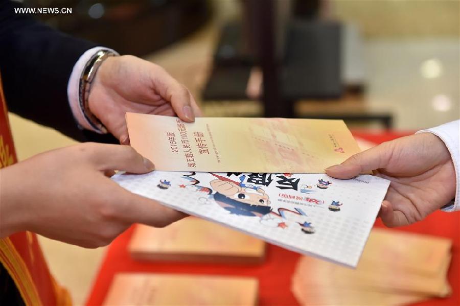 A bank staff member hands publicity brochure of new 100-yuan banknotes to a customer at the Beijing Branch of the Bank of Communication in Beijing, capital of China, Nov. 12, 2015. China's central bank released a new 100-yuan banknote on Thursday. The design stays largely the same as its former series, but the new banknotes are harder to conterfeit and easier for machines to read. The 100-yuan note is the largest denomination of the Chinese currency. [Xinhua]