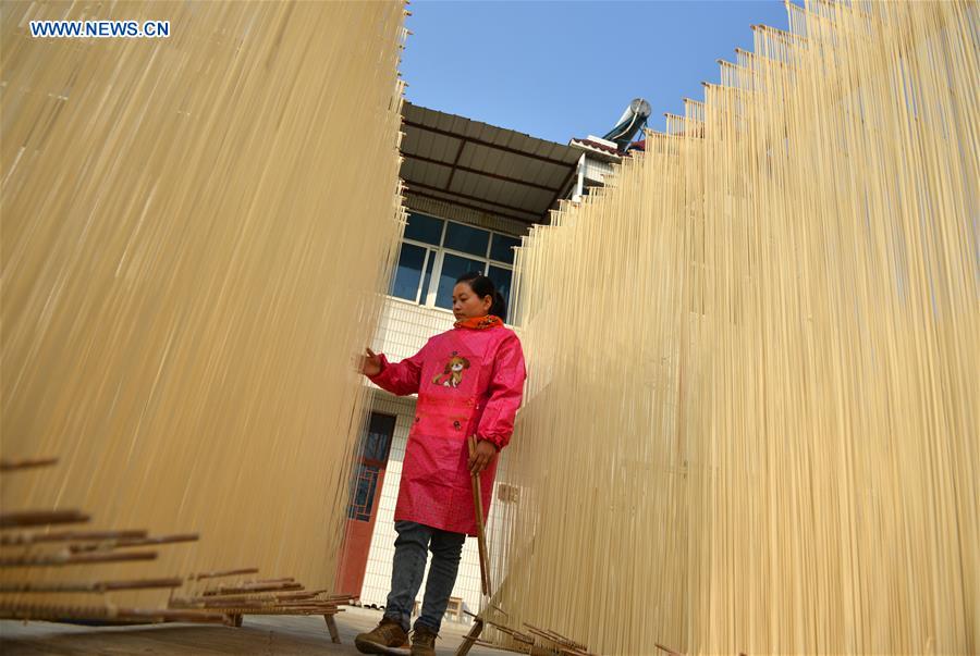 Villager Liang Xuqin checks the dried vermicelli in Linze Village, Huaian City of east China's Jiangsu Province, Nov. 12, 2015. Linze Village, long famous for its handmade vermicelli, has passed on the traditional handicraft for about one hundred years. [Xinhua]