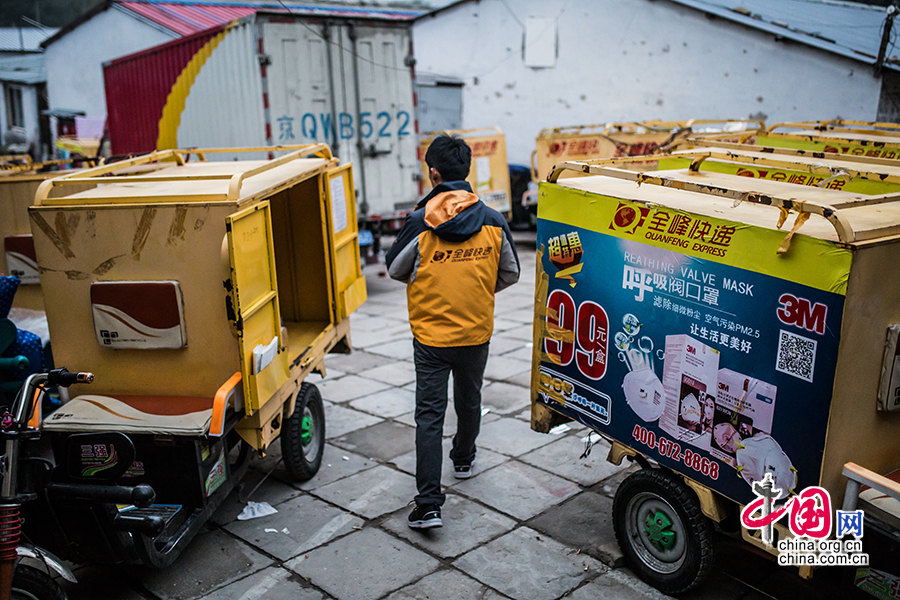 Hou arrives at the company offices. Electric motorcycles used for dispatching the goods are parked everywhere in the yard. [Photo by Zheng Liang/China.org.cn]