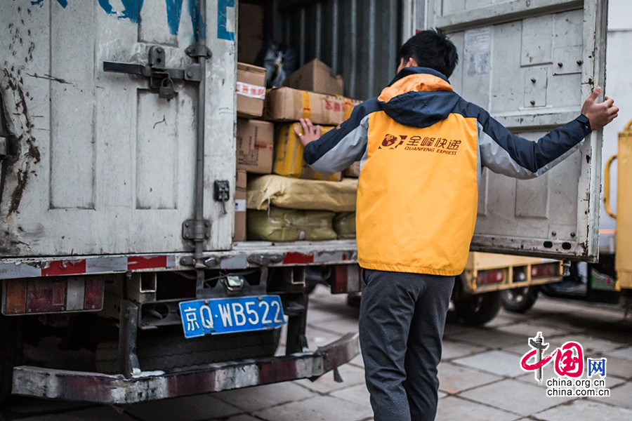 Hou arrives in the company and examines the goods piled on a truck for dispatch. [Photo by Zheng Liang/China.org.cn]