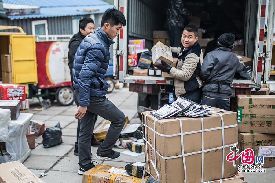  Hou and his co-workers make an inventory of the day's deliveries assigned by the company. [Photo by Zheng Liang/China.org.cn] 