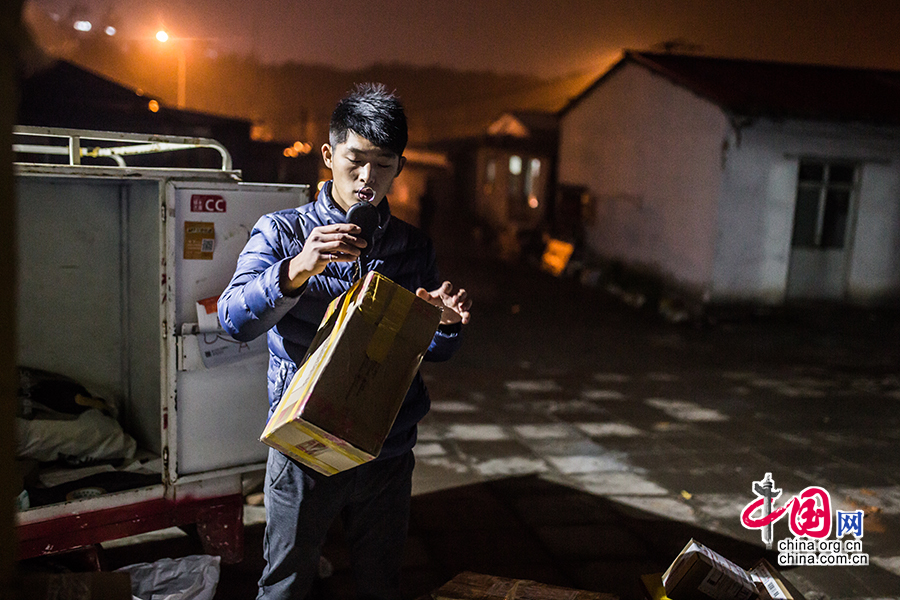 Hou carefully examines the goods before finishing his day's work. [Photo/China.org.cn]